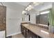 Well-lit bathroom featuring double vanity, granite countertop, and decorative mirror, with a bathtub at 9604 Stoney Mesa Ct, Las Vegas, NV 89139