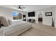 Large bedroom featuring light wood-look flooring, a ceiling fan, and an ensuite bathroom at 9604 Stoney Mesa Ct, Las Vegas, NV 89139