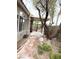 Spacious backyard with a stone pathway, mature trees, and a covered patio area at 9621 Donner Springs Ave, Las Vegas, NV 89148