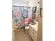 Bright bathroom featuring a floral shower curtain and white vanity with tile flooring at 9621 Donner Springs Ave, Las Vegas, NV 89148