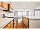 Open-concept kitchen with stainless steel appliances, wood cabinets, and a view into the living space at 9987 Shiloh Heights St, Las Vegas, NV 89178