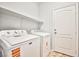 Efficient laundry room equipped with a washing machine, dryer, and overhead shelving for storage at 9987 Shiloh Heights St, Las Vegas, NV 89178