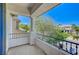 Charming balcony featuring stucco columns and wrought iron railing, overlooking lush greenery at 10249 Wisteria Hills Ct, Las Vegas, NV 89135