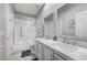 Bright bathroom featuring dual sinks, quartz countertop, framed mirrors, shower over tub and tile flooring at 10249 Wisteria Hills Ct, Las Vegas, NV 89135