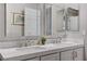 Close up of bright bathroom featuring dual sinks, quartz countertop, framed mirrors, and tile flooring at 10249 Wisteria Hills Ct, Las Vegas, NV 89135
