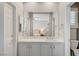 Bright bathroom with white vanity and countertops, large mirror, and access to private shower and toilet at 10249 Wisteria Hills Ct, Las Vegas, NV 89135