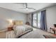 Bright bedroom features neutral colors, ceiling fan, and french doors leading to a balcony at 10249 Wisteria Hills Ct, Las Vegas, NV 89135