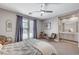 Comfortable bedroom features neutral colors, ceiling fan, and french doors leading to a balcony at 10249 Wisteria Hills Ct, Las Vegas, NV 89135