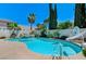 Backyard featuring a pool, spa, waterslide, basketball hoop, and mature trees at 10249 Wisteria Hills Ct, Las Vegas, NV 89135