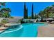 Inviting backyard pool and spa area surrounded by lush landscaping and palm trees at 10249 Wisteria Hills Ct, Las Vegas, NV 89135