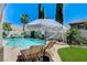 Backyard swimming pool features a slide, basketball hoop, lounge chairs and landscaped greenery at 10249 Wisteria Hills Ct, Las Vegas, NV 89135