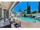 Inviting backyard featuring a pool, spa, waterslide, basketball hoop, palm trees, and covered patio seating area at 10249 Wisteria Hills Ct, Las Vegas, NV 89135