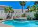Backyard featuring a pool, spa, mature trees, and white brick perimeter fence at 10249 Wisteria Hills Ct, Las Vegas, NV 89135