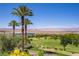 Scenic view of a golf course and lake surrounded by lush greenery, palm trees, and distant mountains at 12 Strada Di Circolo, Henderson, NV 89011