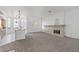 Spacious living room with fireplace, carpet, and view into the kitchen at 12 Strada Di Circolo, Henderson, NV 89011