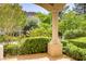 Charming outdoor patio with lush landscaping and a decorative column at 12 Strada Di Circolo, Henderson, NV 89011