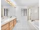 Bright bathroom with double sink vanity, soaking tub, and shower with gold trim at 1951 Moyer Dr, Henderson, NV 89074