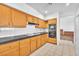 Functional kitchen boasts wood cabinetry, tile floors, a white backsplash, black countertops, and modern appliances at 1951 Moyer Dr, Henderson, NV 89074
