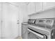 Modern laundry room featuring front loading washer and dryer with white cabinets at 1951 Moyer Dr, Henderson, NV 89074