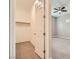 Walk-in closet with shelving and carpet flooring, adjacent to a bedroom with ceiling fan at 208 Coltrane Canyon Ave, Henderson, NV 89011