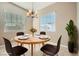 Cozy dining area with modern chandelier, large windows, and stylish decor at 208 Coltrane Canyon Ave, Henderson, NV 89011
