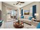 Staged living room with modern furniture, blue accents, and access to the backyard at 208 Coltrane Canyon Ave, Henderson, NV 89011