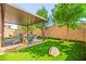 Low-maintenance backyard oasis with covered patio, fire pit, artificial grass and lush trees at 2333 Mundare Dr, Henderson, NV 89002