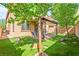 Large backyard with covered patio, artificial grass, mature trees and manicured landscaping at 2333 Mundare Dr, Henderson, NV 89002