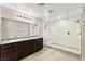 Modern bathroom with dual sinks, granite countertops, and a large walk-in shower with glass enclosure at 2333 Mundare Dr, Henderson, NV 89002