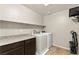 Convenient laundry room features washer, dryer, counterspace and shelving for supplies at 2333 Mundare Dr, Henderson, NV 89002