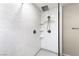 Modern shower featuring a rainfall showerhead, handheld sprayer, and built-in shelves at 2333 Mundare Dr, Henderson, NV 89002