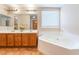 The bathroom has a double sink vanity, soaking tub, and wood cabinets at 2608 Campobello Ave, North Las Vegas, NV 89081