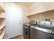 The laundry room features updated washer and dryer, as well as shelving for storage at 2608 Campobello Ave, North Las Vegas, NV 89081