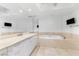 Bright bathroom features marble counters, soaking tub, and large mirror, complete with a wall-mounted television at 2777 Paradise Rd # 303, Las Vegas, NV 89109