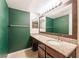 Well-lit bathroom with granite vanity, dark wood cabinets, and green accent wall at 2866 Loveland Dr # 2018, Las Vegas, NV 89109