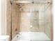 Close-up of a shower over tub with glass doors and neutral-toned tile surround at 2866 Loveland Dr # 2018, Las Vegas, NV 89109