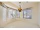 Bright breakfast nook with three large windows and a vintage chandelier creating a cozy dining space at 3104 Hayden Ct, Las Vegas, NV 89134