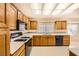 Functional kitchen layout featuring oak cabinets, laminate countertops and a gas range at 3104 Hayden Ct, Las Vegas, NV 89134