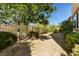 Landscaped backyard with gravel, trees, shrubs and partial fencing providing a private outdoor space at 33 Via Di Mello, Henderson, NV 89011