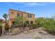 Exterior view of a two-story home with desert landscaping and a wrought iron fence at 33 Via Di Mello, Henderson, NV 89011