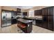 Well-appointed kitchen with dark cabinets, stainless steel appliances, and a convenient center island at 33 Via Di Mello, Henderson, NV 89011