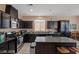 Modern kitchen features dark cabinets, stainless steel appliances, granite countertops and a center island at 33 Via Di Mello, Henderson, NV 89011