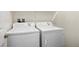Functional laundry room with a top-loading washing machine and a front-loading dryer at 33 Via Di Mello, Henderson, NV 89011