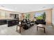 Open concept layout with black kitchen cabinets, island seating, and carpeted living space at 33 Via Di Mello, Henderson, NV 89011