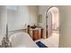 Modern bathroom with a beautiful tub, a decorative sink, and an arched doorway at 4162 Matterhorn Way, Las Vegas, NV 89124