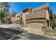 Unique home with stone accents and a large garage, surrounded by mature trees at 4162 Matterhorn Way, Las Vegas, NV 89124