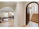 Hallway view with a staircase with hardwood steps and a door with an arched frame at 4162 Matterhorn Way, Las Vegas, NV 89124