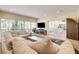 Comfortable living room featuring a large sectional, TV, and access to outdoor balcony with lush views at 4162 Matterhorn Way, Las Vegas, NV 89124