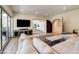Spacious living room with TV, comfortable sectional, and balcony overlooking a lush, wooded area at 4162 Matterhorn Way, Las Vegas, NV 89124