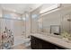 Modern bathroom featuring a stylish vanity with a large mirror, framed by contemporary lighting fixtures, and a tub with shower at 4290 Solace St, Las Vegas, NV 89135